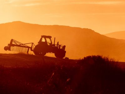 tractor-in-farm-field-at-sunset-backlight-warm-tones